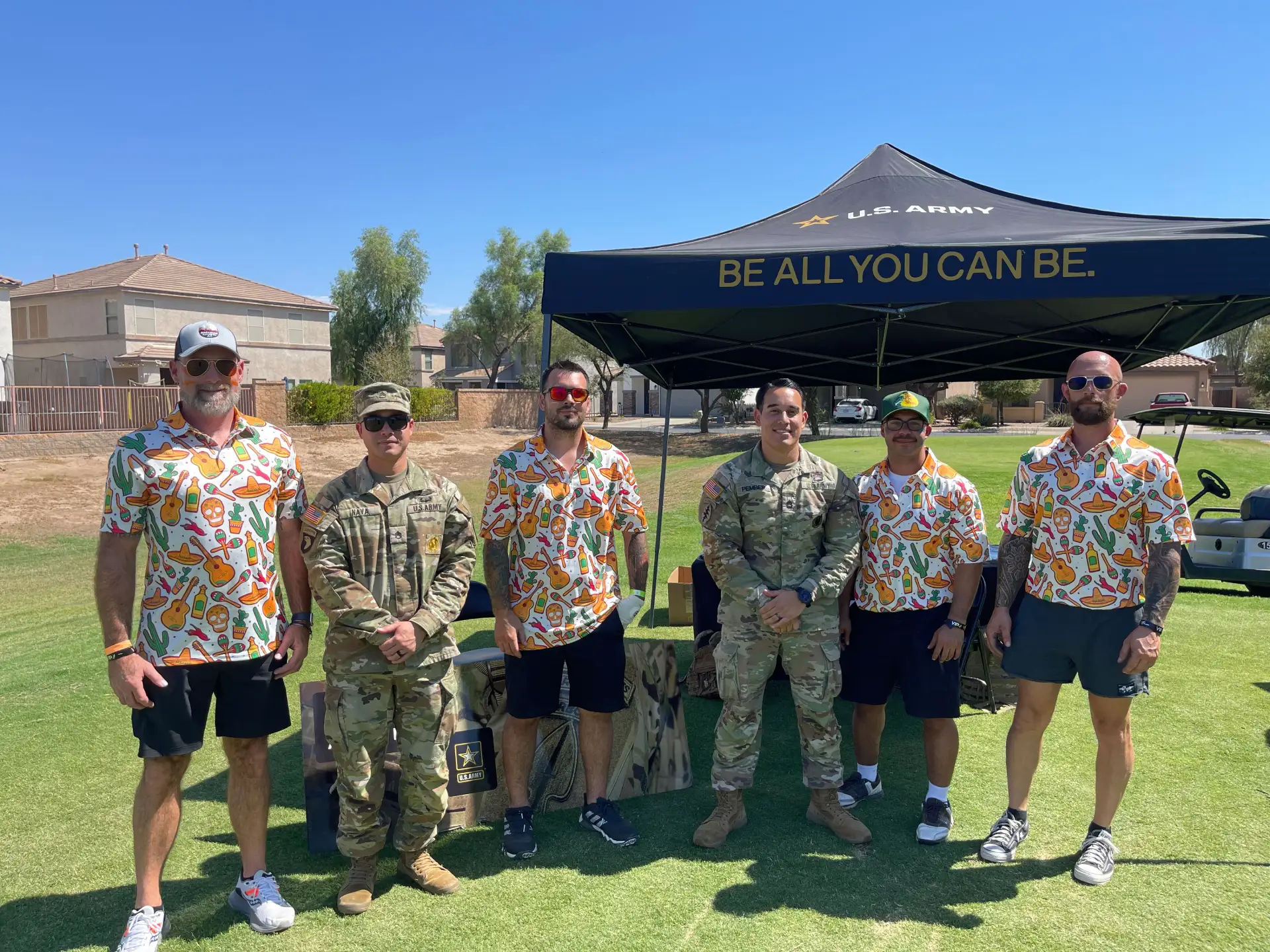 Group photo with U.S. Army personnel under an Army tent, suggesting support from a Gilbert, AZ plumber.